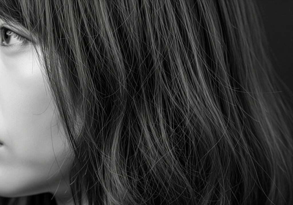 デジタルパーマの失敗例である、チリチリに傷んでしまった日本人女性の髪の毛のアップ。